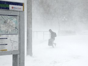A traveler walks through the snow and ice to get to the Metro Government Center Plaza station as the snow picked up in downtown Minneapolis, Saturday, April 14, 2018.   The National Weather Service predicts 9 to 15 inches of snow across a large swath of southern Minnesota including the Twin Cities before it's all over. (Anthony Souffle/Star Tribune via AP) ORG XMIT: MNMIT504