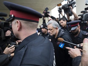 Father of the accused , Vahe Minassian is escorted out of the 1000 Finch Court by police officers after his son Alek Minassian was charged with 10 counts of first degree & 13 counts of attempted murder on Tuesday April 24, 2018. (Stan Behal/Toronto Sun)