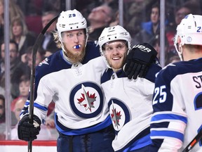 Winnipeg Jets forwards Patrik Laine (left) and Nikolaj Ehlers celebrate a goal against the Montreal Canadiens on April 3.