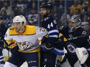 Winnipeg Jets defenceman Josh Morrissey (centre) deals with Nashville Predators forward Miikka Salomaki in front of goaltender Connor Hellebuyck in Winnipeg on Sun., March 25, 2018. Kevin King/Winnipeg Sun/Postmedia Network