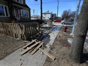A downed fence and debris are seen at a home on Winnipeg Avenue at Arlington Street in Winnipeg on Sunday, after a stolen car and another vehicle collided there in the early-morning hours.