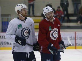 Josh Morrissey (right) and Kyle Connor chat during Winnipeg Jets practice at Bell MTS Iceplex on Monday.