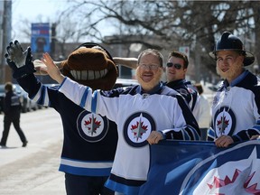 United Firefighters of Winnipeg president Alex Forrest (second left) and others firefighters are joined by Winnipeg Jets mascot Mick E. Moose during a media event at the Firefighters Museum on Maple Street in Winnipeg on Monday, where it was announced all city fire trucks will fly the Jets flag for the duration of their stay in the NHL playoffs.