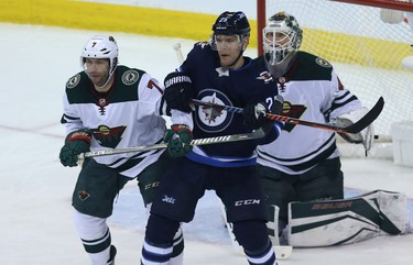 Winnipeg Jets centre Paul Stastny (centre) battles for space in front of Minnesota Wild goaltender Devan Dubnyk with centre Matt Cullen during Game 1 of their first-round NHL playoff series in Winnipeg on Wed., April 11, 2018. Kevin King/Winnipeg Sun/Postmedia Network