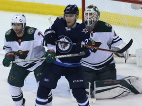 Winnipeg Jets centre Paul Stastny (centre) battles for space in front of Minnesota Wild goaltender Devan Dubnyk with centre Matt Cullen during Game 1 of their first-round NHL playoff series in Winnipeg on Wed., April 11, 2018. Kevin King/Winnipeg Sun/Postmedia Network