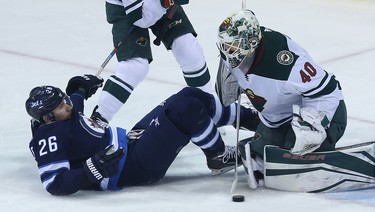 Winnipeg Jets forward Blake Wheeler is knocked to the ice as a shot slides into Minnesota Wild goaltender Devan Dubnyk during Game 1 of their first-round NHL playoff series in Winnipeg on Wed., April 11, 2018. Kevin King/Winnipeg Sun/Postmedia Network