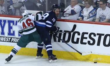 Winnipeg Jets centre Bryan Little (right) looks for a play as he's pinned by Minnesota Wild defenceman Jared Spurgeon during Game 1 of their first-round NHL playoff series in Winnipeg on Wed., April 11, 2018. Kevin King/Winnipeg Sun/Postmedia Network