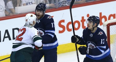 Winnipeg Jets centre Adam Lowry tussles with Minnesota Wild forward Nino Niederreiter as Brandon Tanev steps in during Game 1 of their first-round NHL playoff series in Winnipeg on Wed., April 11, 2018. Kevin King/Winnipeg Sun/Postmedia Network