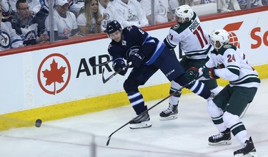 Winnipeg Jets defenceman Jacob Trouba (left) clears a puck under pressure from Minnesota Wild forward Zach Parise (centre) and defenceman Matt Dumba during Game 1 of their first-round NHL playoff series in Winnipeg on Wed., April 11, 2018. Kevin King/Winnipeg Sun/Postmedia Network