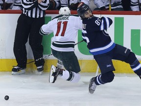 Winnipeg Jets forward Mathieu Perreault (right) is spilled by Minnesota Wild forward Zach Parise during Game 1 of their first-round NHL playoff series in Winnipeg on Wed., April 11, 2018. Kevin King/Winnipeg Sun/Postmedia Network