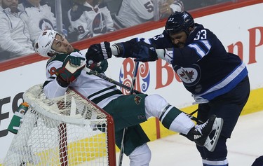 Winnipeg Jets defenceman Dustin Byfuglien (right) pushes  Minnesota Wild forward Jason Zucker into the net during Game 1 of their first-round NHL playoff series in Winnipeg on Wed., April 11, 2018. Kevin King/Winnipeg Sun/Postmedia Network