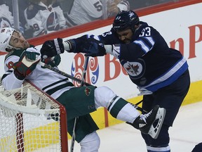 Winnipeg Jets defenceman Dustin Byfuglien (right) pushes  Minnesota Wild forward Jason Zucker into the net during Game 1 of their first-round match on Wednesday night. (Kevin King/Winnipeg Sun/Postmedia Network)