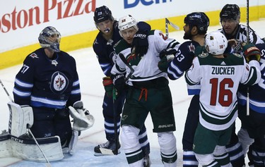 Winnipeg Jets forward Patrik Laine (second left) grabs  Minnesota Wild forward Nino Neiderreiter during a scrum in Game 1 of their first-round NHL playoff series in Winnipeg on Wed., April 11, 2018. Kevin King/Winnipeg Sun/Postmedia Network