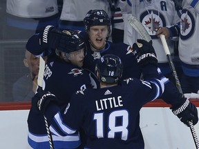Winnipeg Jets defenceman Tyler Myers (top) celebrates his goal against the Minnesota Wild with Andrew Copp (left) and Bryan Little during Game 2 on Friday.