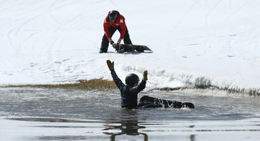 Wyatt Lambert, a 13-year-old from Stonewall, raises his arms in mock celebration after wiping out during the season-ending Slush Cup at Stony Mountain Ski Area in Stony Mountain, Man., on Sun., April 15, 2018. Kevin King/Winnipeg Sun/Postmedia Network