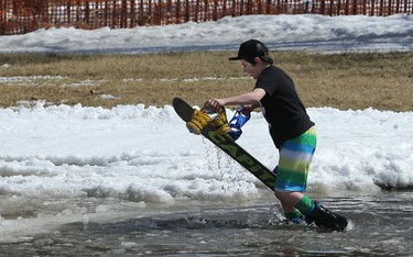 Damian Harrison, 13, takes off his board and gloves and hustles out of the cold warted after coming up short of the other side during the season-ending Slush Cup at Stony Mountain Ski Area in Stony Mountain, Man., on Sun., April 15, 2018. Kevin King/Winnipeg Sun/Postmedia Network