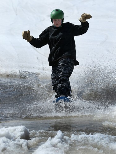 A youngster crosses the pond on his snowboard during the season-ending Slush Cup at Stony Mountain Ski Area in Stony Mountain, Man., on Sun., April 15, 2018. Kevin King/Winnipeg Sun/Postmedia Network