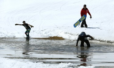 Wyatt Lambert (right), 13, pulls himself out of the drink while Damien Harrison, also 13, hits the water during the season-ending Slush Cup at Stony Mountain Ski Area in Stony Mountain, Man., on Sun., April 15, 2018. Kevin King/Winnipeg Sun/Postmedia Network