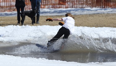 A snowboarder crosses the pond during the season-ending Slush Cup at Stony Mountain Ski Area in Stony Mountain, Man., on Sun., April 15, 2018. Kevin King/Winnipeg Sun/Postmedia Network