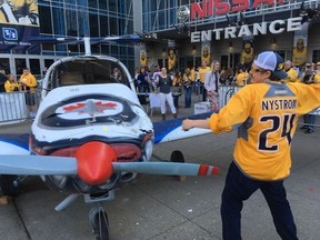 A Predators fan takes a hammer to an airplane painted in Jets colours and decorated with a Jets logo as part of a charity-driven tradition outside Bridgestone Arena ahead of Game 1 between the Nashville Predators and the Winnipeg Jets on Friday.