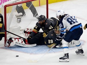 Mathieu Perreault of the Winnipeg Jets misses a shot on goal as Pierre-Edouard Bellemare falls on top of goalie Marc-Andre Fleury of the Vegas Golden Knights at T-Mobile Arena on May 16, 2018 in Las Vegas.  (Isaac Brekken/Getty Images)