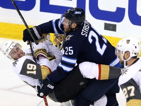Jets' Paul Stastny and Golden Knights' Reilly Smith mix it up on Monday during Game 2 of the West final. (THE CANADIAN PRESS)