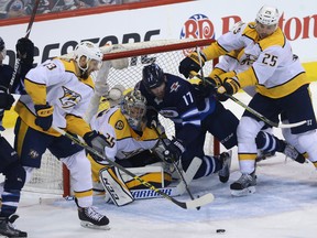 Jets centre Adam Lowry falls into Nashville Predators goaltender Pekka Rinne during Game 3 last night. The Jets stormed back from a 3-0 deficit to win. (Kevin King/Winnipeg Sun)