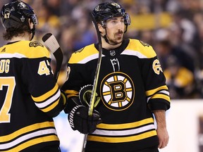 Torey Krug of the Boston Bruins and Brad Marchand look on during Game 4 against the Tampa Bay Lightning at TD Garden on May 4, 2018