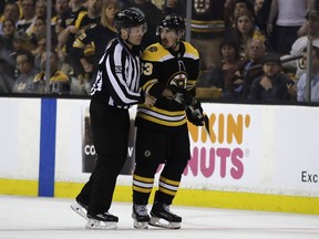 Boston Bruins forward Brad Marchand is escorted to the penalty box during the second period of Game 3 of NHL playoff series against the Tampa Bay Lightning in Boston. on May 2, 2018.