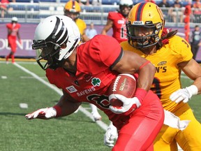 Carleton Ravens Dexter Brownruns beyond Queen's Gaels Jake Firlotte during the second half of Ontario University Athletics action at Richardson Stadium in Kingston, Ont. on Saturday August 26, 2017. The Ravens defeated the Gaels 22-17. Steph Crosier/Kingston Whig-Standard/Postmedia Network