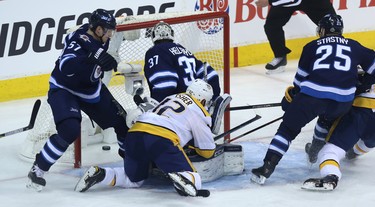 Nashville Predators centre Mike Fisher pokes the puck past Winnipeg Jets goaltender Connor Hellebuyck during Game 2 of their second-round playoff series in Winnipeg on Tues., May 1, 2018. Kevin King/Winnipeg Sun/Postmedia Network