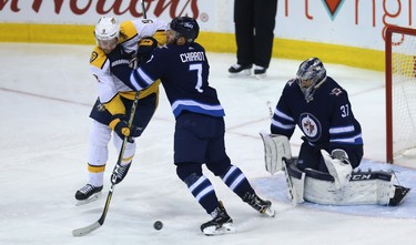 Winnipeg Jets defenceman Ben Chiarot (centre) defends against Nashville Predators forward Filip Forsberg in front of goaltender Connor Hellebuyck during Game 2 of their second-round playoff series in Winnipeg on Tues., May 1, 2018. Kevin King/Winnipeg Sun/Postmedia Network