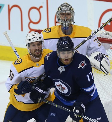 Winnipeg Jets centre Adam Lowry (right) battles for position in front of Nashville Predators goaltender Pekka Rinne with Roman Josi during Game 2 of their second-round playoff series in Winnipeg on Tues., May 1, 2018. Kevin King/Winnipeg Sun/Postmedia Network