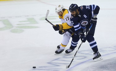 Winnipeg Jets defenceman Dustin Byfuglien (right) battles for the puck with Nashville Predators forward Scott Hartnell during Game 4 of their second-round NHL playoff series in Winnipeg on Thurs., May 3, 2018. Kevin King/Winnipeg Sun/Postmedia Network