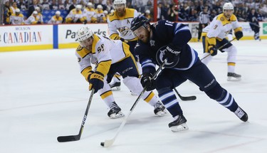 A bloody-nosed Winnipeg Jets forward Bryan Little throws a backhand at the Nashville Predators net as he's angled off by defenceman Roman Josi during Game 4 of their second-round NHL playoff series in Winnipeg on Thurs., May 3, 2018. Kevin King/Winnipeg Sun/Postmedia Network