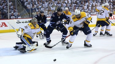 Winnipeg Jets centre Adam Lowry (centre) and Nashville Predators defenceman P.K. Subban (right) get after a puck during Game 4 of their second-round NHL playoff series in Winnipeg on Thurs., May 3, 2018. Kevin King/Winnipeg Sun/Postmedia Network