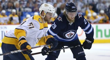 Winnipeg Jets forward Patrik Laine (right) lines up against Nashville Predators forward Austin Watson during Game 4 of their second-round NHL playoff series in Winnipeg on Thurs., May 3, 2018. Kevin King/Winnipeg Sun/Postmedia Network