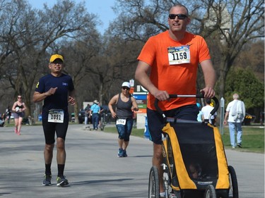A half-marathon runner with stroller in tow nears the finish line of the Winnipeg Police Service half marathon in Assiniboine Park in Winnipeg on Sun., May 6, 2018. Kevin King/Winnipeg Sun/Postmedia Network