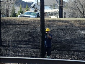 A Manitoba Hydro employee does his part to deal with what police called a brush fire near the intersection of Sterling Lyon Parkway and Shaftesbury Boulevard in Winnipeg on Sun., May 6, 2018. People were asked to leave the Assiniboine Forest and Sterling Lyon was closed westbound at Shaftesbury while the Winnipeg Police Service and Winnipeg Fire Paramedic Services dealt with it, police said. Kevin King/Winnipeg Sun/Postmedia Network