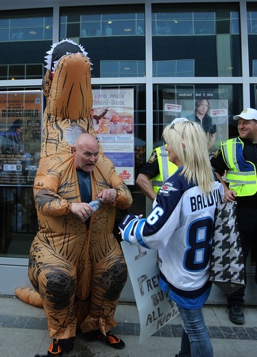 A man in a dinosaur costume takes a breather at the Whiteout Street Party prior to the Winnipeg Jets facing the Nashville Predators in Game 6 of their NHL playoff series in Winnipeg on Mon., May 7, 2018. Kevin King/Winnipeg Sun/Postmedia Network