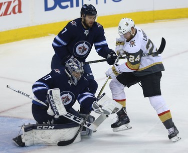 Winnipeg Jets goaltender Connor Hellebuyck makes a save as Ben Chiarot defends against Vegas Golden Knights centre Oscar Lindberg during Game 1 of their Western Conference final series in Winnipeg on Sat., May 12, 2018. Kevin King/Winnipeg Sun/Postmedia Network