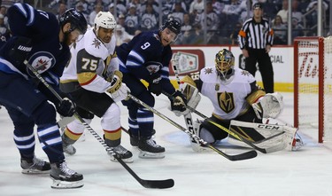 Winnipeg Jets centre Adam Lowry (left) tries to get a pass through to Andrew Copp as Vegas Golden Knights forward Ryan Reaves defends in front of Marc-Andre Fleury during Game 1 of their Western Conference final series in Winnipeg on Sat., May 12, 2018. Kevin King/Winnipeg Sun/Postmedia Network