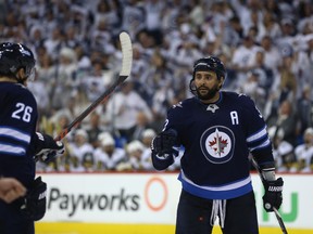 Winnipeg Jets defenceman Dustin Byfuglien (right) left Saturday’s practice early with an upper-body injury after tumbling into the boards and is considered day-to-day, according to Jets head coach Paul Maurice.