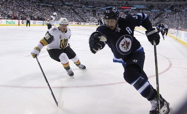 Winnipeg Jets centre Mark Scheifele (right) tries to spin away from the checking of Vegas Golden Knights defenceman Nate Schmidt during Game 1 of their Western Conference final series in Winnipeg on Sat., May 12, 2018. Kevin King/Winnipeg Sun/Postmedia Network