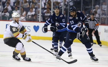 Winnipeg Jets defenceman Dustin Byfuglien fires the puck as Vegas Golden Knights forward Jonathan Marchessault closes during Game 1 of their Western Conference final series in Winnipeg on Sat., May 12, 2018. Kevin King/Winnipeg Sun/Postmedia Network