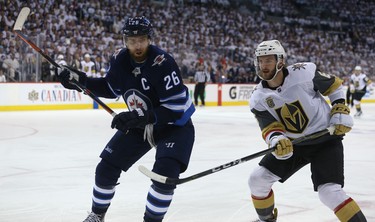 Winnipeg Jets forward Blake Wheeler (left) and Vegas Golden Knights defenceman Colin Miller battle for a loose puck during Game 1 of their Western Conference final series in Winnipeg on Sat., May 12, 2018. Kevin King/Winnipeg Sun/Postmedia Network