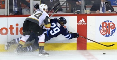 Winnipeg Jets forward Patrik Laine (right) is knocked to the ice by Vegas Golden Knights centre Oscar Lindberg during Game 1 of their Western Conference final series in Winnipeg on Sat., May 12, 2018. Kevin King/Winnipeg Sun/Postmedia Network