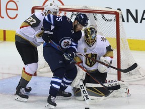 Winnipeg Jets centre Paul Stastny (centre) fights for a loose puck in front of Vegas Golden Knights goaltender Marc-Andre Fleury with defenceman Shea Theodore in tow during Game 2 Monday.