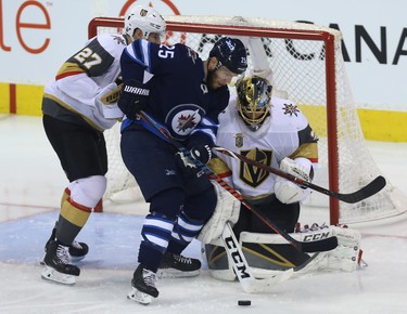 Winnipeg Jets centre Paul Stastny (centre) fights for a loose puck in front of Vegas Golden Knights goaltender Marc-Andre Fleury with defenceman Shea Theodore in tow during Game 2 of the Western Conference final in Winnipeg on Mon., May 14, 2018. Kevin King/Winnipeg Sun/Postmedia Network
