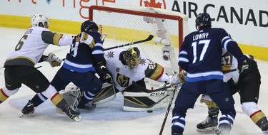 The Winnipeg Jets fight for a loose puck in front of Vegas Golden Knights goaltender Connor Hellebuyck during Game 2 of the Western Conference final in Winnipeg on Mon., May 14, 2018. Kevin King/Winnipeg Sun/Postmedia Network